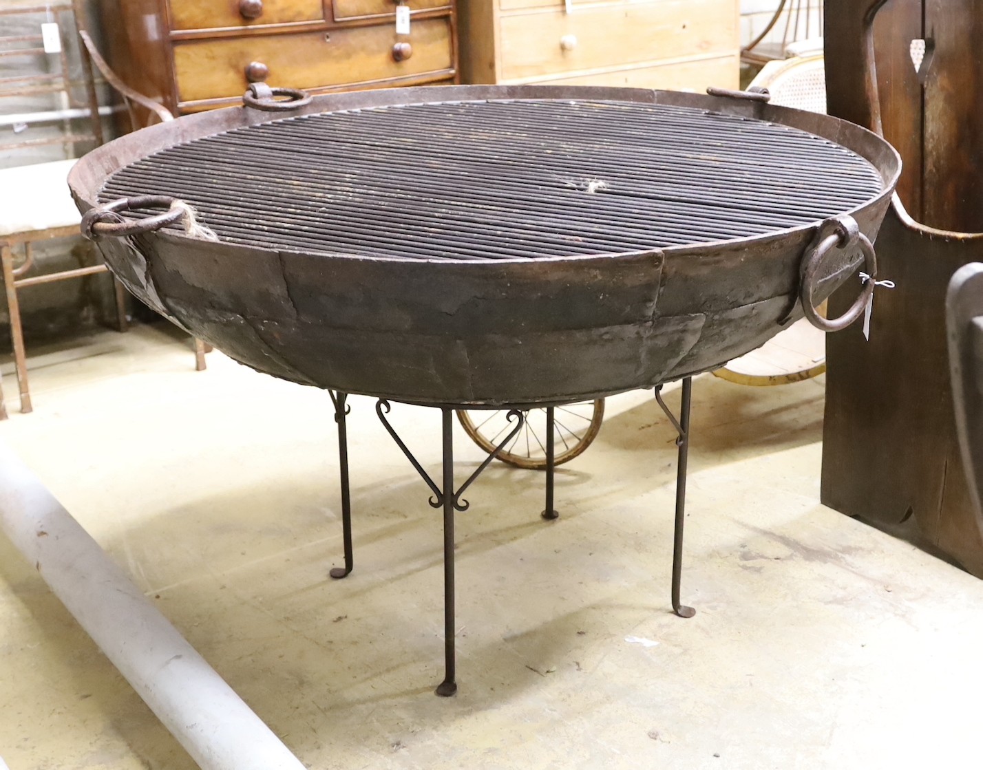 A large riveted fire pit on stand with grill, diameter 133cm height 83cm